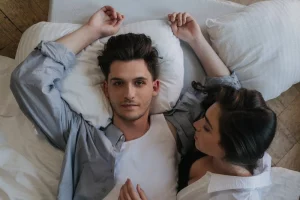 a man and a woman lying on the bed